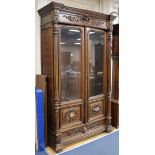 A mid 19th century French carved oak Renaissance style two door glazed bookcase W.130cm, H.220cm