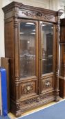 A mid 19th century French carved oak Renaissance style two door glazed bookcase W.130cm, H.220cm