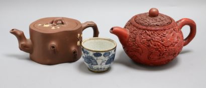 Two Yixing teapots, one with carved cinnabar lacquer decoration and a tea bowl