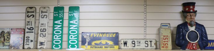 An American car fender and tin signs, car plates etc