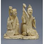 A Japanese ivory okimono of two figures holding sceptres