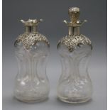 A pair of Edwardian repousse silver mounted glass waisted glug decanters and one stopper, 24.7cm