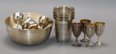 A set of four sterling silver engraved beakers, two sets of six miniature silver goblets and an