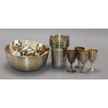 A set of four sterling silver engraved beakers, two sets of six miniature silver goblets and an