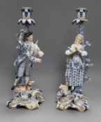 A pair of Meissen musical shepherd and shepherdess candlesticks, glazed in blue, white and gilt on