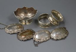 A set of three modern silver wine labels, one other silver wine label, two silver napkin rings and a