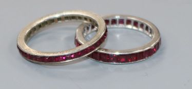 A platinum and ruby eternity ring and one other eternity ring.