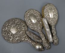 Five assorted repousse silver mounted brushes, mirror etc.