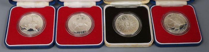 Four UK commemorative silver coins, cased