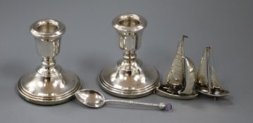 A pair of modern silver candlesticks, two Italian white metal model yachts and a silver spoon.