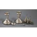 A pair of modern silver candlesticks, two Italian white metal model yachts and a silver spoon.