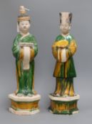 A pair of Chinese sancai tall pottery figures of attendants