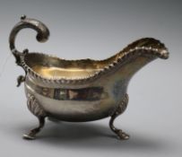 A George III silver sauce boat, crested, having gadrooned rim, scrolled acanthus handle and three
