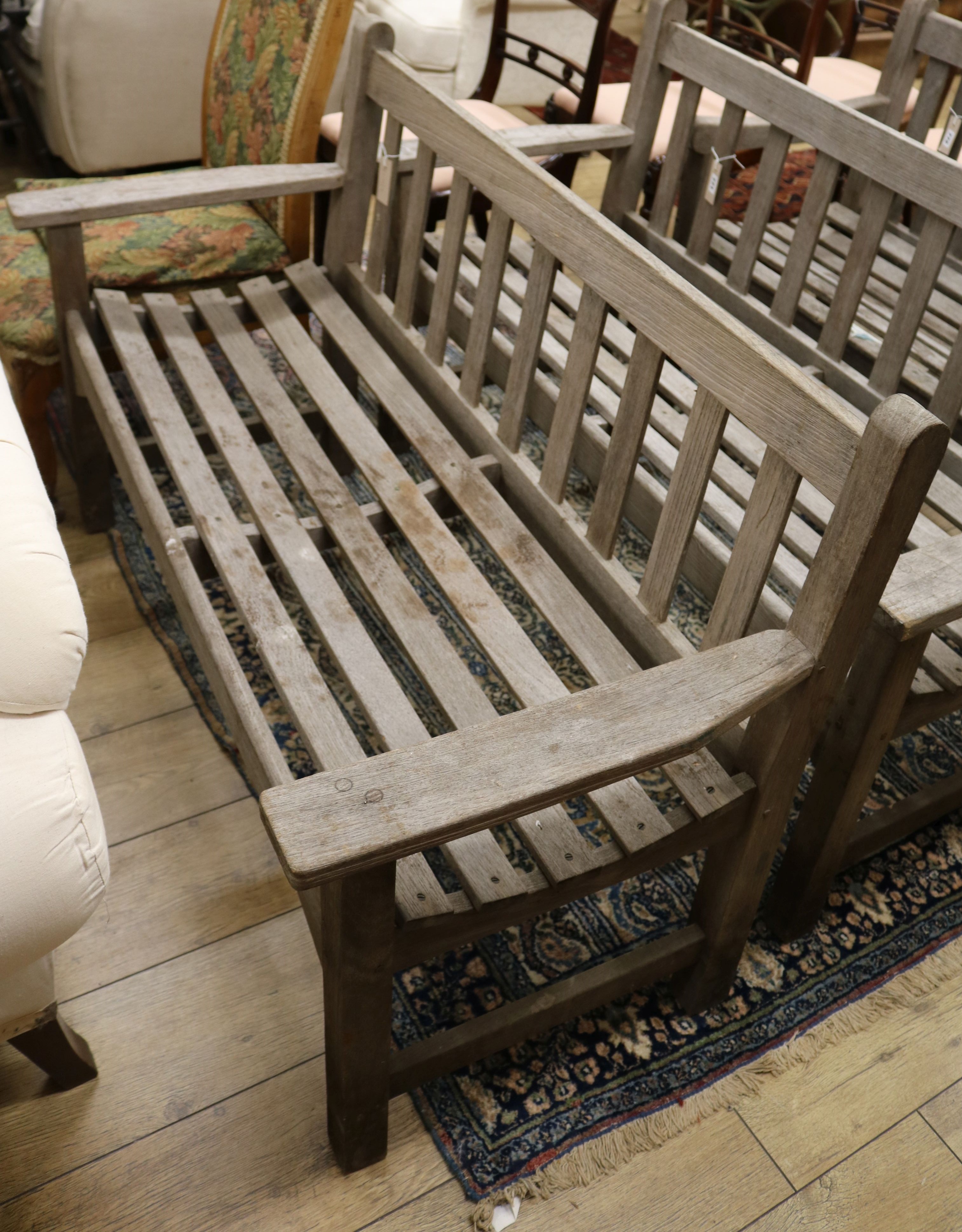 A teak garden bench with slatted seat W.128cm