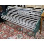 A Victorian green painted wrought iron and teak garden bench and a teak garden bench with slightly