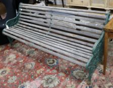 A Victorian green painted wrought iron and teak garden bench and a teak garden bench with slightly