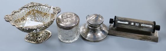 A silver desk calendar, a silver inkwell, silver bonbon dish and a silver lidded toilet jar.