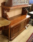 A Victorian mahogany buffet, with panel and shelf above, on openwork S scroll supports, with three