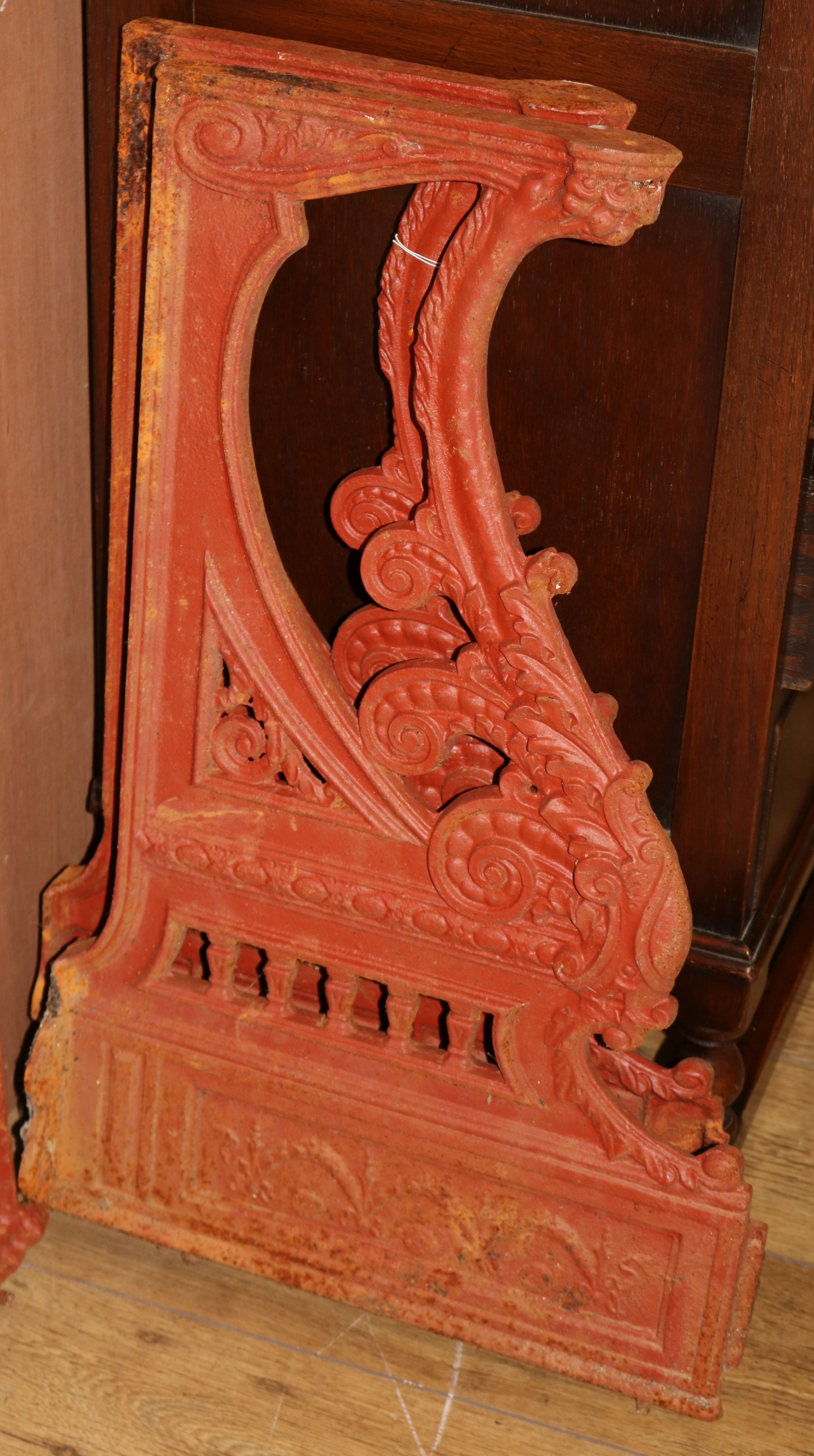 A pair of Victorian Athenian style red painted cast iron bench ends W.44cm