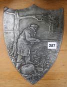 A metal plaque of fisherman with reel