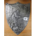 A metal plaque of fisherman with reel