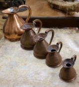 A set of graduated copper jugs