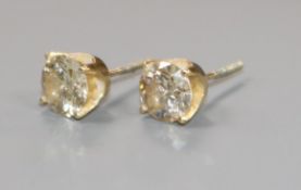 A pair of yellow metal mounted solitaire diamond ear studs, each stone weighing approximately just