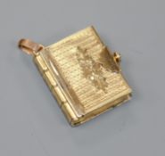 A Victorian engraved yellow metal book shaped portrait locket, 23mm.