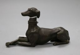 A bronze recumbent greyhound, front paws crossed, stamped 2396 to underside, lacking base, H 10cm