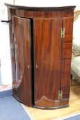 A George III bow-fronted hanging corner cupboard W.68cm