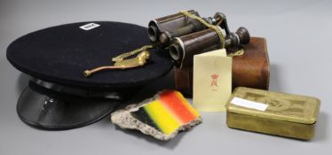 A pair of World War I binoculars, a military cap, tin and whistle and a piece of the Berlin wall