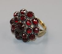 A Victorian yellow metal mounted facet cut garnet cluster ring, size G.