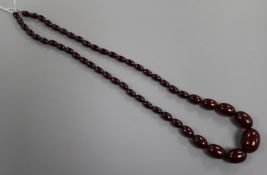 A single strand simulated cherry amber bead necklace, gross weight 59 grams, 74cm.