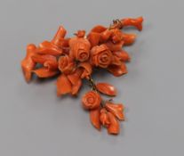 A carved coral floral spray drop brooch, carved with roses, width 68mm.