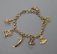 A yellow metal charm bracelet, hung with seven assorted charms including 9ct gold, gross 15.4