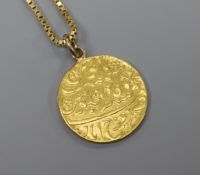 A Persian yellow metal coin mounted as a pendant on a 9ct gold chain.