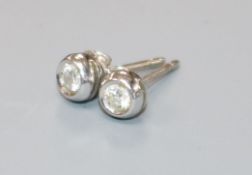 A pair of white metal and solitaire diamond ear studs, the butterflies stamped 750.