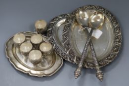 A collection of Burmese 900 white metal, including a pair of salad servers with ornately chased
