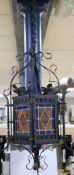 A wrought iron stained glass panel hanging lantern
