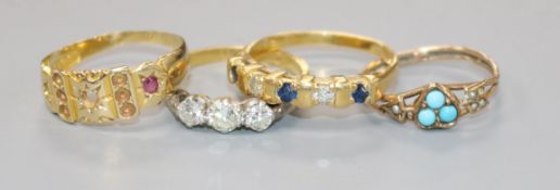 An 18ct gold and three stone diamond ring and three other gem set rings including one 9ct and one