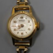 A lady's 18ct gold Roamer manual wind wrist watch, on a 9ct gold bracelet.
