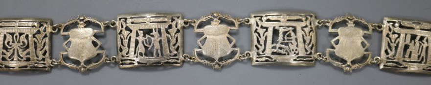 An Egyptian? white metal belt, pierced and decorated with scarabs and figures, 93cm.