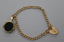 An early 20th century 9ct gold curb link bracelet hung with a yellow metal mounted carnelian and