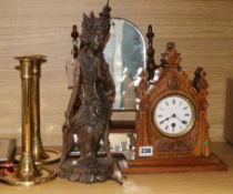 A late Victorian carved oak timepiece, a pair of brass candlesticks, a toilet mirror and a carved