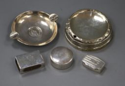 Two white metal pill boxes, two silver ashtrays and a silver match sleeve.