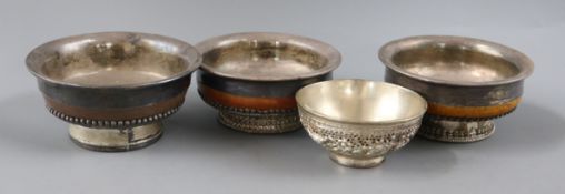 Four Tibetan white metal and wood bowls largest 10cm