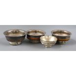 Four Tibetan white metal and wood bowls largest 10cm