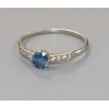 An early/mid 20th century white metal, single stone sapphire ring with diamond set shoulders, size