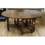 An early 18th century style gateleg oak dining table W.186cm