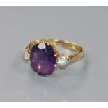 An 18ct gold amethyst and diamond three stone dress ring, size O.